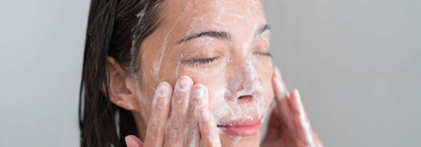 lady washing her face | alcohol in skin care