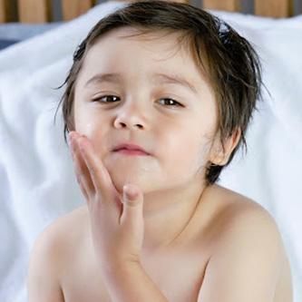 Is Using Lotion Candle For Kids Safe? kid touching his face | lotion candle for kids